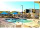 Community pool with lounge chairs and umbrellas offers a relaxing outdoor space at 12800 Oceano Dunes Ct, Henderson, NV 89044