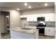 Modern kitchen featuring a center island with granite countertops and stainless steel appliances at 12800 Oceano Dunes Ct, Henderson, NV 89044