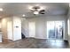 Open-concept living area with tile floors, ceiling fan, and access to a patio via sliding glass doors at 12800 Oceano Dunes Ct, Henderson, NV 89044