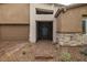 The home features a modern entrance with a stylish stone facade, desert landscaping, and a brick walkway leading to the front door at 135 Barnett Crest Ct, Henderson, NV 89015