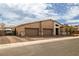 A modern home with a three car garage, desert landscaping, and a walkway leading to the front door at 135 Barnett Crest Ct, Henderson, NV 89015