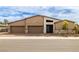 This modern home features a three car garage, desert landscaping, a stylish stone facade, and a walkway leading to the front door at 135 Barnett Crest Ct, Henderson, NV 89015