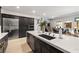 Bright kitchen showcasing a large island with sink, stainless steel appliances, and dark cabinetry at 135 Barnett Crest Ct, Henderson, NV 89015