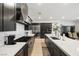 Bright kitchen with large island, stainless steel appliances, dark cabinets, and view into dining area at 135 Barnett Crest Ct, Henderson, NV 89015
