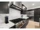Close-up of the kitchen featuring stainless steel range, coffee maker, and dark cabinets with marble backsplash at 135 Barnett Crest Ct, Henderson, NV 89015