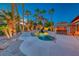 This backyard features a custom pool, spa, and covered outdoor bar area surrounded by palm trees at 1983 Songbird Ct, Henderson, NV 89012