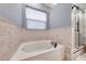 This bathroom highlights a soaking tub with patterned tiling and a window with blinds above at 1983 Songbird Ct, Henderson, NV 89012