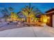 Exterior of a desert home featuring professional landscaping, exterior lighting, and manicured trees at 1983 Songbird Ct, Henderson, NV 89012