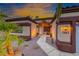 Charming single-Gathering home showcasing desert landscaping and a warm, inviting entrance at dusk at 1983 Songbird Ct, Henderson, NV 89012