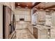 Gourmet island kitchen featuring granite counters, stainless appliances and wood ceiling beams with recessed lighting at 1983 Songbird Ct, Henderson, NV 89012