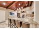 Gourmet island kitchen featuring granite counters, stainless appliances, a breakfast bar and wood ceiling beams at 1983 Songbird Ct, Henderson, NV 89012
