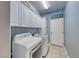 This laundry room features modern washer and dryer units and plenty of cabinet space at 1983 Songbird Ct, Henderson, NV 89012