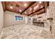 Bright living room featuring a stone fireplace, wood ceiling beams and travertine floors that flow into an island kitchen at 1983 Songbird Ct, Henderson, NV 89012