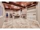 Bright living room featuring a stone fireplace, wood ceiling beams and travertine floors that flow into an island kitchen at 1983 Songbird Ct, Henderson, NV 89012
