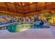 Backyard swimming pool with a rock waterfall, lush landscaping, and a tiki bar at 1983 Songbird Ct, Henderson, NV 89012