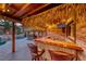 Outdoor tiki bar with a thatched roof, wooden bar, and barstool seating at 1983 Songbird Ct, Henderson, NV 89012