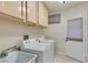 A bright laundry room featuring a sink, counter space, and modern appliances at 2007 High Mesa Dr, Henderson, NV 89012