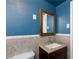 Cozy blue bathroom with tiled walls, stylish vanity, and a framed mirror at 2054 Harvard St, North Las Vegas, NV 89030