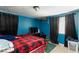Comfortable bedroom with blue walls, tiled flooring, and cozy red and black plaid bedding at 2054 Harvard St, North Las Vegas, NV 89030