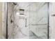 Bathroom showcases a new glass shower with marble-look tile and seat at 206 Lynbrook St, Henderson, NV 89012