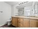 Bright bathroom with a dual sink vanity, granite countertops, and framed mirror at 206 Lynbrook St, Henderson, NV 89012