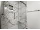Bathroom with a large glass enclosed shower, built-in seat, and a marble tile surround at 206 Lynbrook St, Henderson, NV 89012