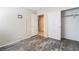 Neutral bedroom with wood-look floors, a closet, a wall-mounted TV bracket, and an open door to the hallway at 206 Lynbrook St, Henderson, NV 89012
