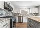 A modern kitchen featuring stainless steel appliances, granite countertops and gray backsplash at 206 Lynbrook St, Henderson, NV 89012