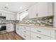 A modern kitchen featuring white cabinets, granite countertops, and stainless steel appliances at 206 Lynbrook St, Henderson, NV 89012