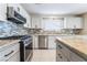 Updated kitchen boasts granite countertops, stainless steel appliances, and mosaic backsplash for modern style at 206 Lynbrook St, Henderson, NV 89012