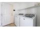 Bright laundry room featuring washer and dryer, white shelving, and white door at 206 Lynbrook St, Henderson, NV 89012