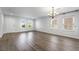 Bright living room featuring wood floors, white walls, multiple windows, and decorative lighting fixture at 206 Lynbrook St, Henderson, NV 89012