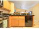 Open kitchen with stainless steel appliances, wood cabinets, black countertops, and tile floors at 2110 Los Feliz St # 2064, Las Vegas, NV 89156