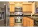 Well-lit kitchen featuring wooden cabinets, stainless steel appliances, and dark countertops at 2110 Los Feliz St # 2064, Las Vegas, NV 89156