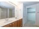 Well-lit bathroom featuring double sinks, a spacious mirror, and a separate walk-in closet at 2152 Turquoise Ridge St # 105, Las Vegas, NV 89117