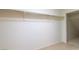A simple walk-in closet includes a metal rod for hanging clothes and neutral carpeting at 2152 Turquoise Ridge St # 105, Las Vegas, NV 89117