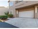 Exterior view displaying a two-car garage with an adjacent walkway, and minimal landscaping at 2152 Turquoise Ridge St # 105, Las Vegas, NV 89117