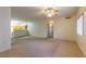 Expansive living room with natural light and neutral carpet, flowing into the kitchen at 2152 Turquoise Ridge St # 105, Las Vegas, NV 89117