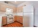 Traditional kitchen with wooden cabinets, white appliances, and wood-look flooring at 2201 Ramsgate Dr # 823, Henderson, NV 89074