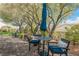 Backyard patio with table, chairs, blue umbrella, and mature landscaping creates an ideal setting for outdoor enjoyment at 2306 Valley Cottage Ave, Henderson, NV 89052