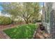This backyard boasts artificial turf, desert landscaping, a shade tree, and ample space for relaxing and entertaining at 2306 Valley Cottage Ave, Henderson, NV 89052
