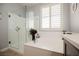 Bright bathroom featuring a glass shower, soaking tub, and plantation shutters at 2306 Valley Cottage Ave, Henderson, NV 89052