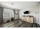 Bright bedroom with wood-look flooring, large window, and a modern entertainment center at 2306 Valley Cottage Ave, Henderson, NV 89052