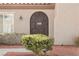 The front door features ornate ironwork and is framed by a lush green bush at 2306 Valley Cottage Ave, Henderson, NV 89052
