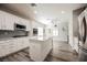 Open kitchen with stainless appliances, white cabinets, large island and gray backsplash at 2306 Valley Cottage Ave, Henderson, NV 89052