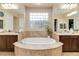 Luxurious bathroom with a central soaking tub and dual vanities at 2665 Chateau Clermont St, Henderson, NV 89044