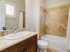 Bathroom featuring a vanity with a stone countertop, a window with shutters and a tiled shower with a tub at 2665 Chateau Clermont St, Henderson, NV 89044