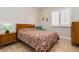 Cozy bedroom featuring a patterned bedspread, a wooden side table with a green lamp, and shuttered windows at 2665 Chateau Clermont St, Henderson, NV 89044