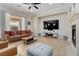 Open living room features a fireplace, tan couches and large sliding glass doors at 2665 Chateau Clermont St, Henderson, NV 89044