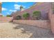 Gravel backyard with privacy wall, lush trees and green landscaping at 2709 Rue Montpellier Ave, Henderson, NV 89044
